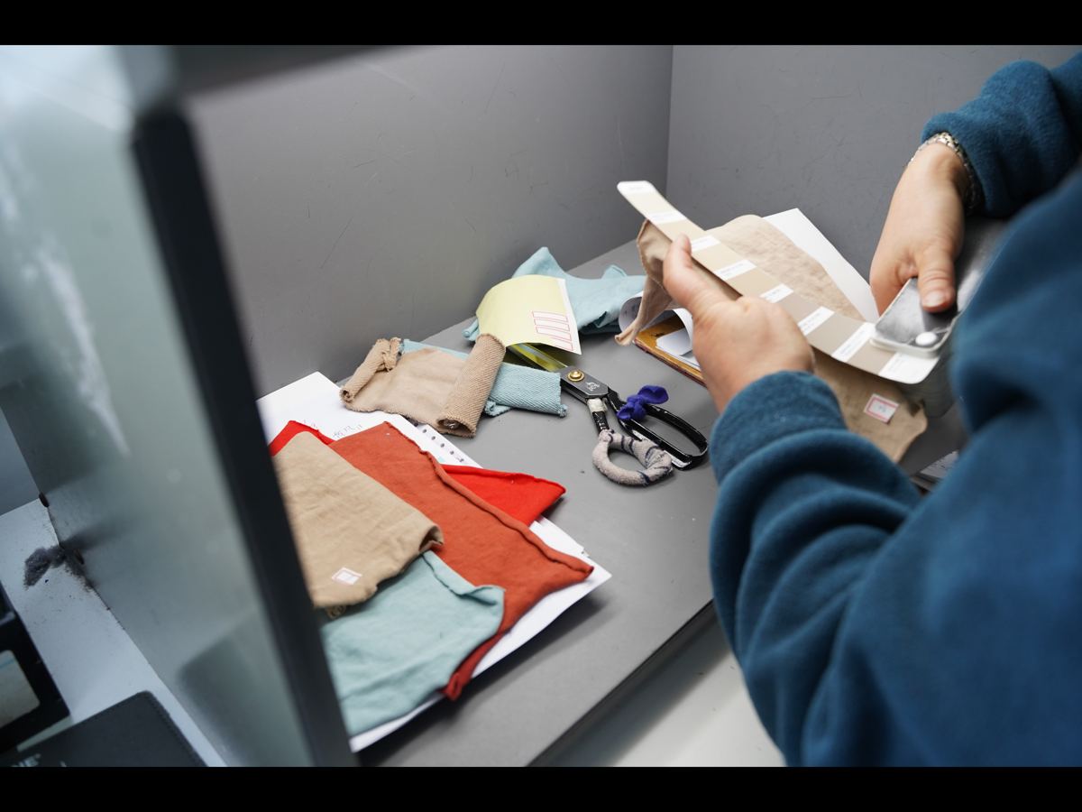Checking fabric swatches against color standards in a light booth